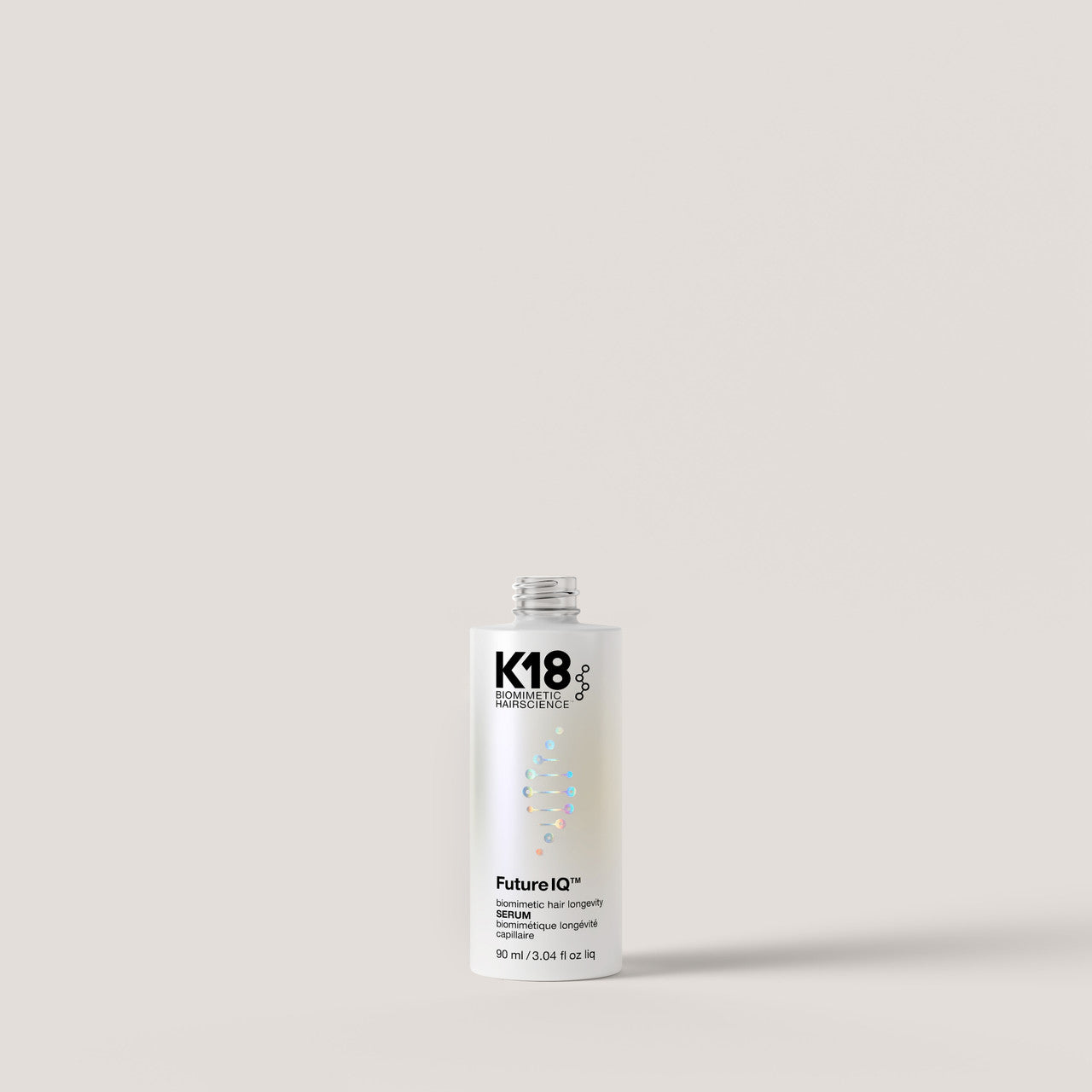 A white bottle of K18 FutureIQ hair growth serum with black text and a holographic logo, centered against a solid light beige background.